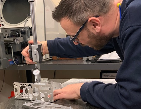 Inspecting a ventilator component for the COVID pandemic. In addition to ISO9001, ISO14001 & OHSAS18001, we have developed our own unique Buffer Management System to enhance manufacturing performance. JOSCAR, SMMT, F4N, CBM and British Safety Council